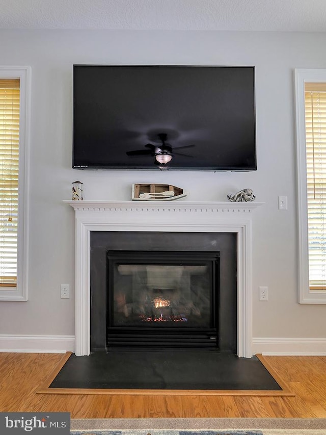37529 Atlantic Ave Unit 11, Rehoboth Beach, DE 19971 - detailed view of baseboards, a fireplace with flush hearth, wood finished floors, and a ceiling fan