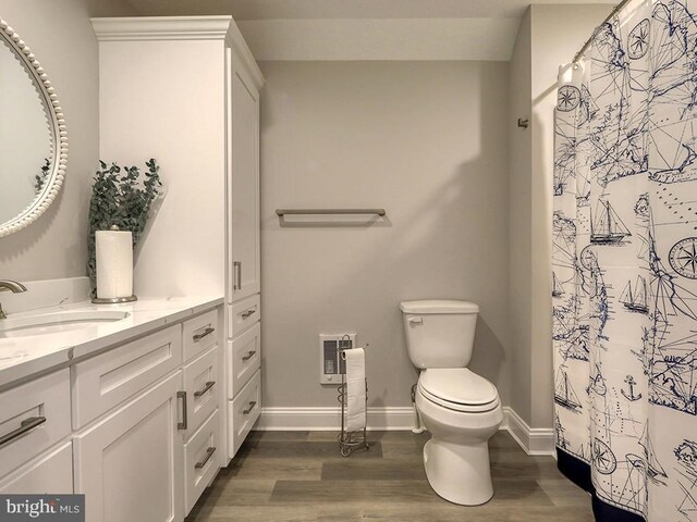37529 Atlantic Ave Unit 11, Rehoboth Beach, DE 19971 - bathroom featuring vanity, wood finished floors, toilet, heating unit, and baseboards