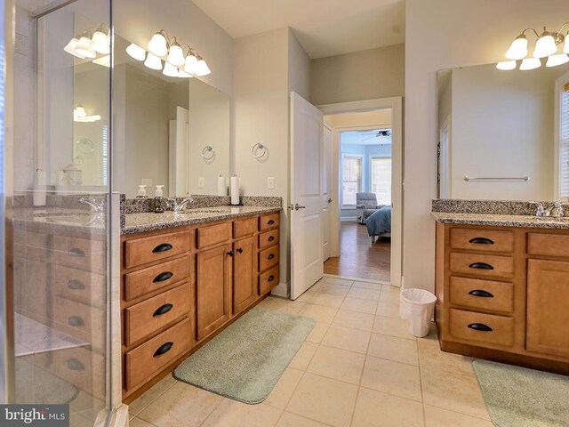 37529 Atlantic Ave Unit 11, Rehoboth Beach, DE 19971 - ensuite bathroom featuring two vanities, a shower stall, tile patterned floors, and ceiling fan