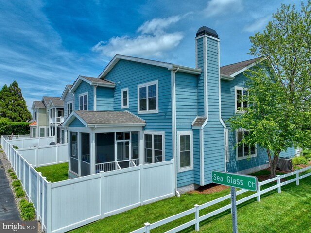 37529 Atlantic Ave Unit 11, Rehoboth Beach, DE 19971 - rear view of property with a sunroom, a chimney, central AC unit, and roof with shingles