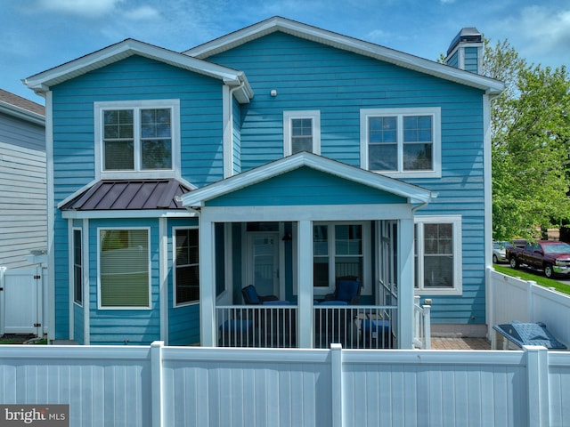 37529 Atlantic Ave Unit 11, Rehoboth Beach, DE 19971 - view of front facade with a fenced backyard, a chimney, and a sunroom