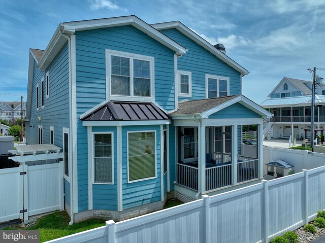 37529 Atlantic Ave Unit 11, Rehoboth Beach, DE 19971 - view of home's exterior with a sunroom, a fenced backyard, and a gate