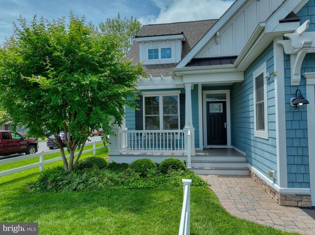 37529 Atlantic Ave Unit 11, Rehoboth Beach, DE 19971 - property entrance featuring a shingled roof, a yard, board and batten siding, and covered porch