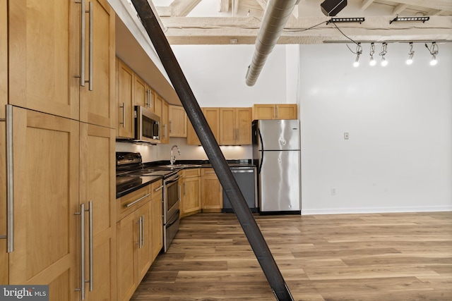 374 Shurs Ln Unit 304, Philadelphia, PA 19128 - kitchen featuring stainless steel appliances, light wood-type flooring, dark countertops, a sink, and baseboards
