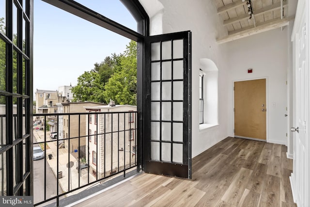 374 Shurs Ln Unit 304, Philadelphia, PA 19128 - doorway featuring wood ceiling with exposed beams, a towering ceiling, wood finished floors, track lighting, and arched walkways