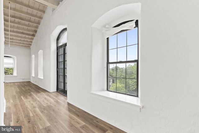 374 Shurs Ln Unit 304, Philadelphia, PA 19128 - unfurnished living room featuring high vaulted ceiling, wood finished floors, wooden ceiling with exposed beams, arched walkways, and baseboards