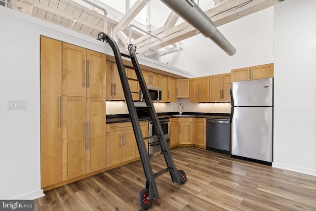 374 Shurs Ln Unit 304, Philadelphia, PA 19128 - kitchen with appliances with stainless steel finishes, dark countertops, wood finished floors, a sink, and baseboards