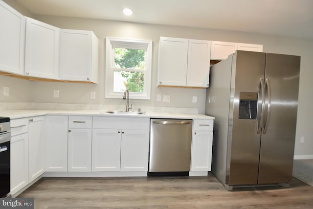 307 4th St, Seaford, DE 19973 - kitchen with stainless steel appliances, a sink, white cabinetry, recessed lighting, and light countertops
