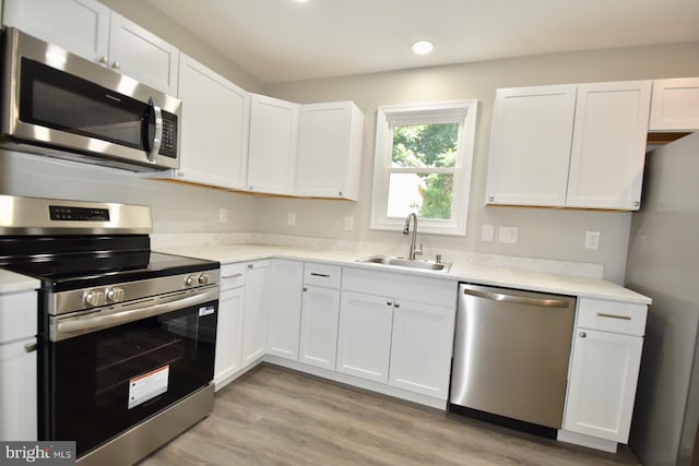 307 4th St, Seaford, DE 19973 - kitchen with stainless steel appliances, a sink, white cabinetry, light countertops, and recessed lighting