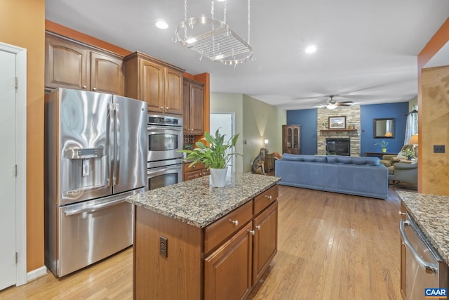 797 Willow Ridge Rd, Troy, VA 22974 - kitchen with stainless steel appliances, light stone counters, a kitchen island, and light wood-style floors