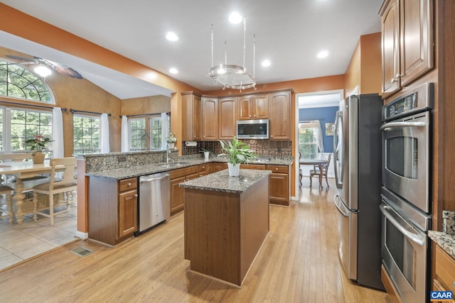 797 Willow Ridge Rd, Troy, VA 22974 - kitchen featuring stainless steel appliances, vaulted ceiling, a kitchen island, light stone countertops, and a peninsula