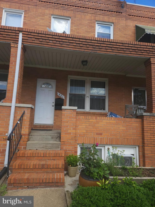 421 Folcroft St, Baltimore, MD 21224 - view of exterior entry featuring brick siding and a porch