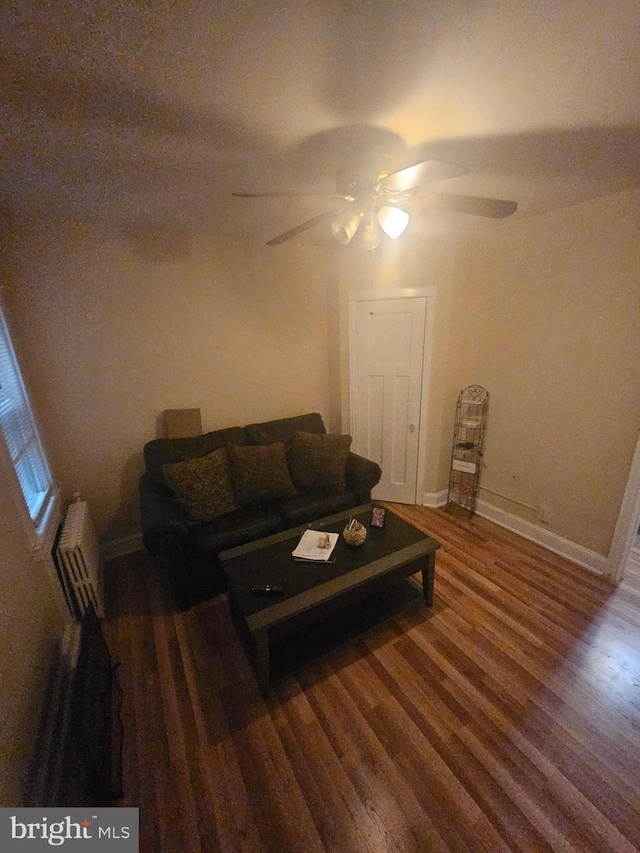 421 Folcroft St, Baltimore, MD 21224 - living area featuring ceiling fan, wood finished floors, baseboards, and radiator heating unit