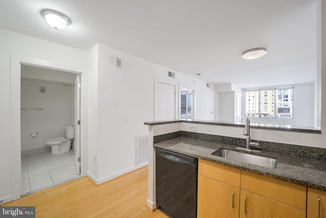 1000 New Jersey Ave SE Unit 315, Washington, DC 20003 - kitchen with dishwasher, a sink, dark stone countertops, light wood-type flooring, and baseboards