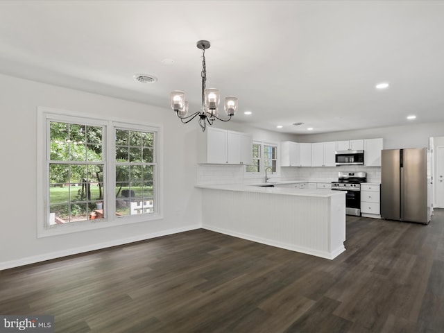 47 Picture Mountain Dr, Martinsburg, WV 25404 - kitchen featuring appliances with stainless steel finishes, a peninsula, a chandelier, dark wood-style flooring, and light countertops