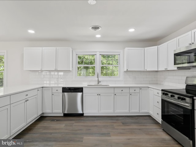 47 Picture Mountain Dr, Martinsburg, WV 25404 - kitchen featuring appliances with stainless steel finishes, white cabinets, light countertops, tasteful backsplash, and dark wood-style flooring