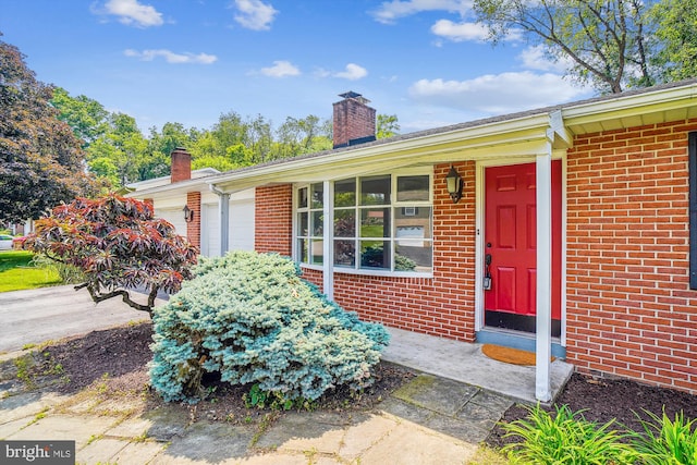 17817 Greentree Ln, Hagerstown, MD 21740 - view of exterior entry featuring a chimney and brick siding