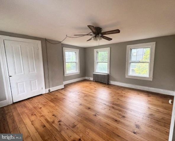 1512 River Rd, Upper Black Eddy, PA 18972 - unfurnished bedroom with radiator, hardwood / wood-style floors, baseboards, and a ceiling fan