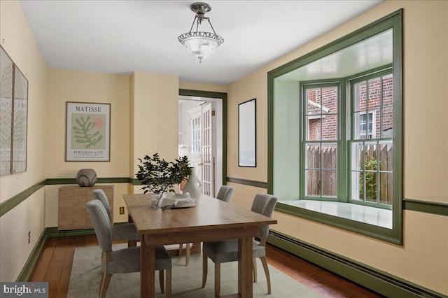 28 The Strand, New Castle, DE 19720 - dining area featuring a baseboard heating unit, wood finished floors, and baseboards