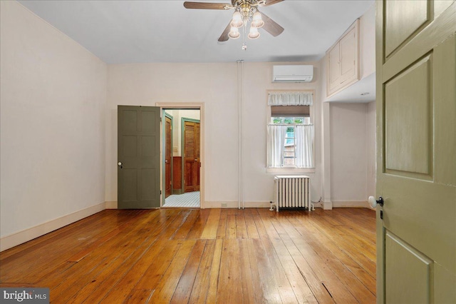 28 The Strand, New Castle, DE 19720 - unfurnished bedroom with radiator heating unit, a wall mounted AC, light wood-type flooring, and baseboards