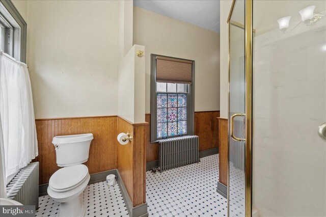 28 The Strand, New Castle, DE 19720 - full bathroom with radiator, a wainscoted wall, a shower stall, toilet, and tile patterned floors