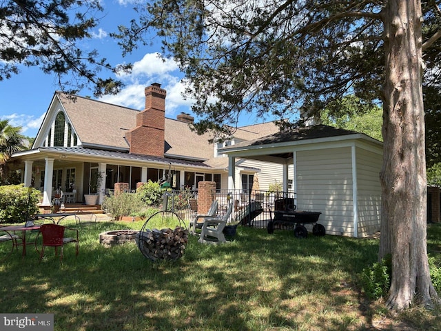 2515 Manion Dr, Williamsburg, VA 23185 - back of house featuring a lawn, an outdoor fire pit, a chimney, roof with shingles, and central AC unit