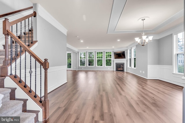 40578 Sculpin Ct, Aldie, VA 20105 - unfurnished living room with a decorative wall, a wainscoted wall, a chandelier, wood finished floors, and stairway