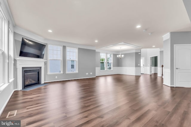 40578 Sculpin Ct, Aldie, VA 20105 - unfurnished living room featuring a fireplace with flush hearth, a chandelier, dark wood finished floors, a wainscoted wall, and crown molding