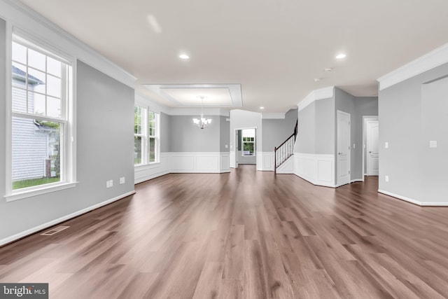 40578 Sculpin Ct, Aldie, VA 20105 - unfurnished living room featuring ornamental molding, a chandelier, wood finished floors, stairway, and wainscoting