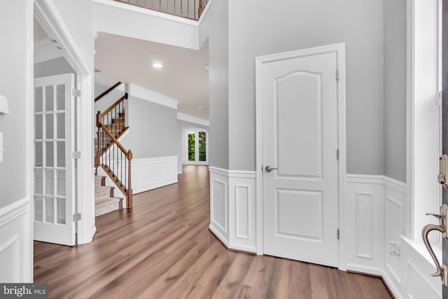40578 Sculpin Ct, Aldie, VA 20105 - foyer entrance featuring stairway, a decorative wall, wood finished floors, wainscoting, and ornamental molding