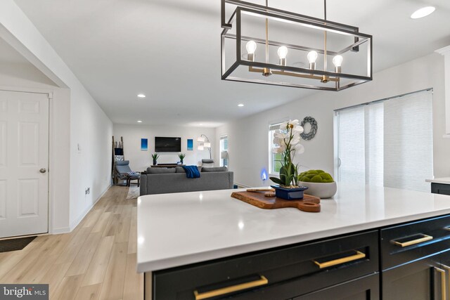 127 Stager Ave, Falling Waters, WV 25419 - kitchen featuring recessed lighting, light countertops, light wood-style floors, dark cabinetry, and decorative light fixtures