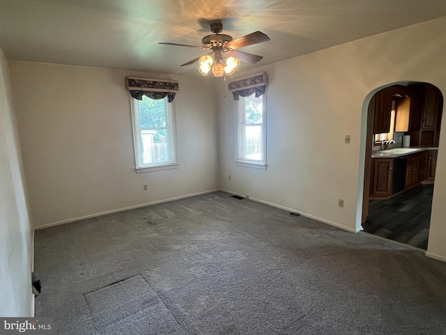 209 S Cherry St, Myerstown, PA 17067 - empty room featuring arched walkways, a ceiling fan, healthy amount of natural light, and dark colored carpet