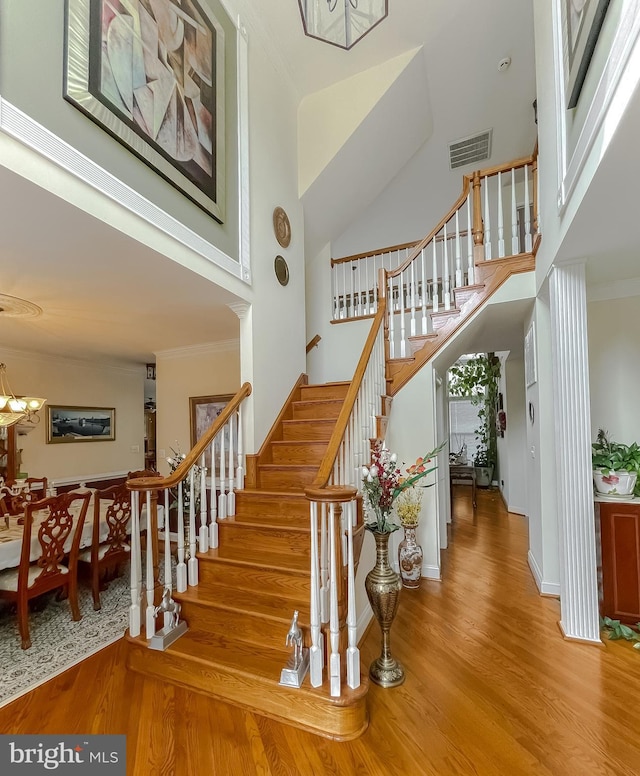 5 Cross Point Dr, Owings, MD 20736 - staircase featuring wood finished floors, a towering ceiling, a chandelier, and crown molding