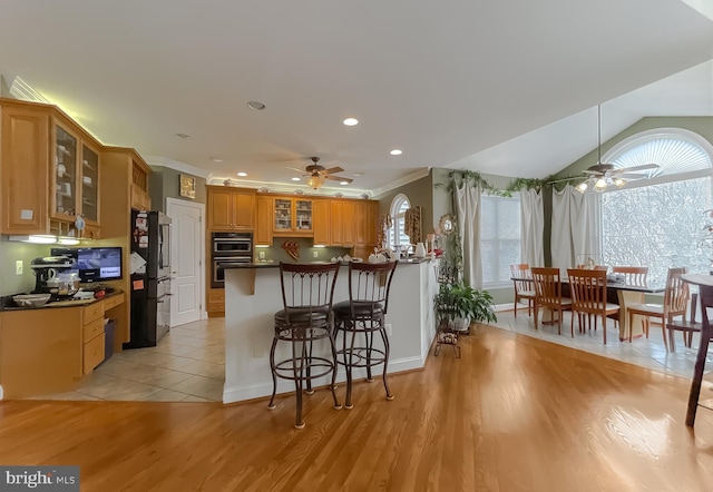 5 Cross Point Dr, Owings, MD 20736 - kitchen with ceiling fan, a peninsula, black appliances, glass insert cabinets, and dark countertops
