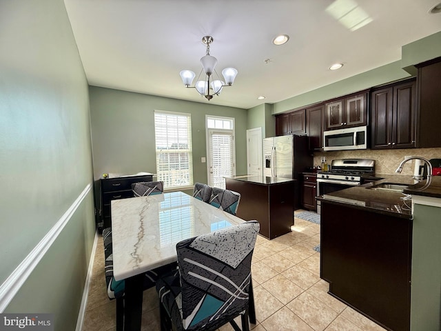 7423 Rigby Pl, Elkridge, MD 21075 - kitchen featuring appliances with stainless steel finishes, tasteful backsplash, a chandelier, dark brown cabinets, and light tile patterned floors