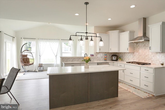 6300 Neha Dr Unit 32, Mechanicsburg, PA 17050 - kitchen featuring wall chimney range hood, light wood-type flooring, gas stovetop, backsplash, and light countertops