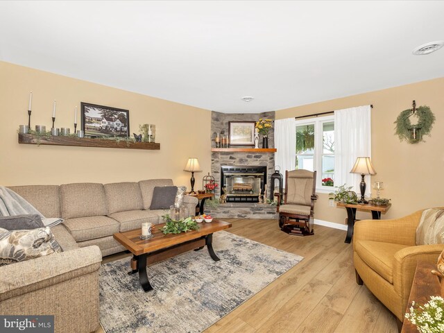 41 E Frederick St, Williamsport, MD 21795 - living room with light wood finished floors, a stone fireplace, and baseboards