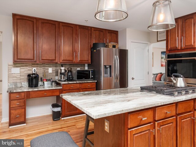 3716 Hill Park Dr, Temple Hills, MD 20748 - kitchen with stainless steel appliances, light wood-style floors, tasteful backsplash, brown cabinetry, and light stone counters