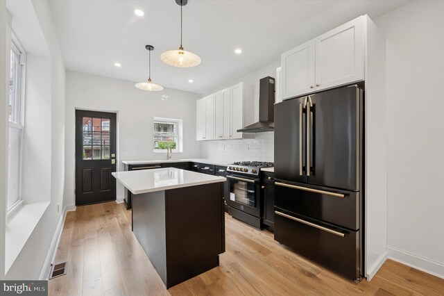1740 N 61st St, Philadelphia, PA 19151 - kitchen featuring high quality fridge, stainless steel gas range oven, wall chimney exhaust hood, white cabinets, and light countertops