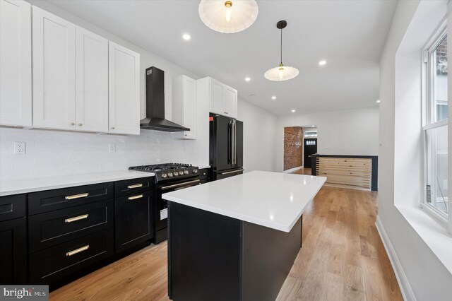 1740 N 61st St, Philadelphia, PA 19151 - kitchen featuring wall chimney range hood, black appliances, dark cabinetry, white cabinetry, and backsplash