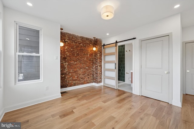 1740 N 61st St, Philadelphia, PA 19151 - unfurnished bedroom with brick wall, a barn door, light wood-type flooring, baseboards, and recessed lighting