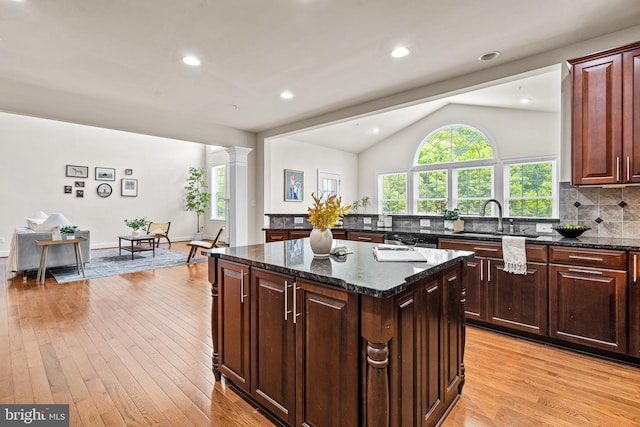 4403 Cedar Reach Ln, Bowie, MD 20720 - kitchen featuring a kitchen island, lofted ceiling, tasteful backsplash, light wood-type flooring, and dark stone countertops