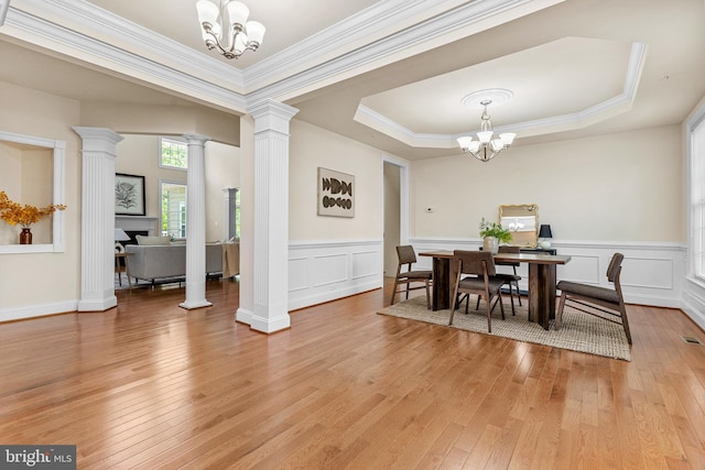 4403 Cedar Reach Ln, Bowie, MD 20720 - dining room featuring a chandelier, light wood-style flooring, decorative columns, a decorative wall, and a tray ceiling