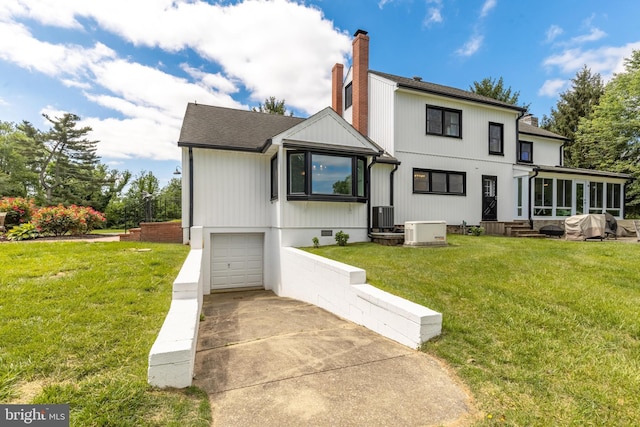 65 Hillcrest Ln, North East, MD 21901 - back of property featuring a chimney, a sunroom, a garage, driveway, and a lawn