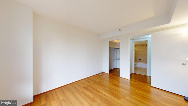 1808 Old Meadow Rd Unit 1015, Mclean, VA 22102 - unfurnished bedroom featuring light wood-type flooring, a closet, a spacious closet, and baseboards