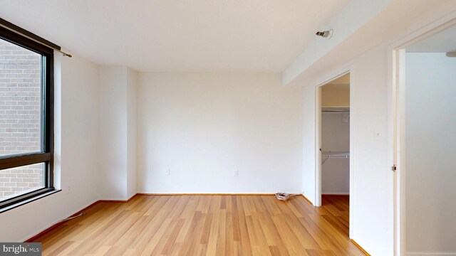 1808 Old Meadow Rd Unit 1015, Mclean, VA 22102 - unfurnished bedroom with light wood finished floors, a walk in closet, a closet, and baseboards
