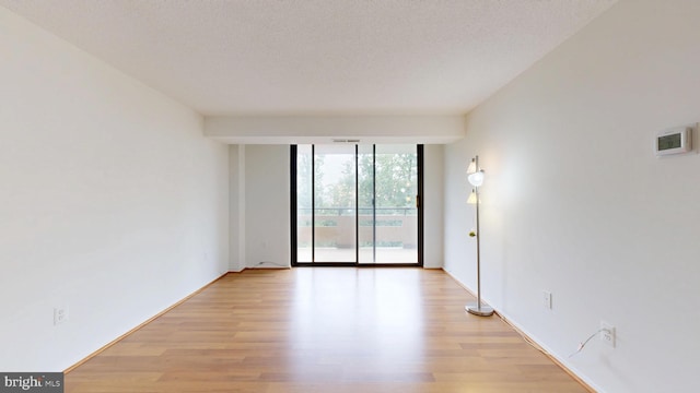 1808 Old Meadow Rd Unit 1015, Mclean, VA 22102 - empty room with expansive windows, light wood-style floors, and a textured ceiling