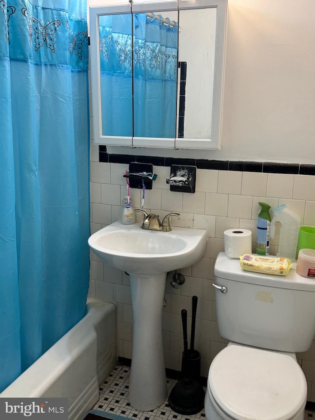 4029 Cedardale Rd, Baltimore, MD 21215 - full bathroom featuring tile walls, toilet, shower / bath combination with curtain, and wainscoting