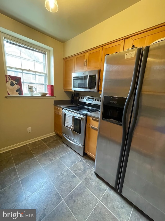3750 39th St NW Unit C147, Washington, DC 20016 - kitchen with stainless steel appliances, baseboards, dark countertops, and brown cabinets