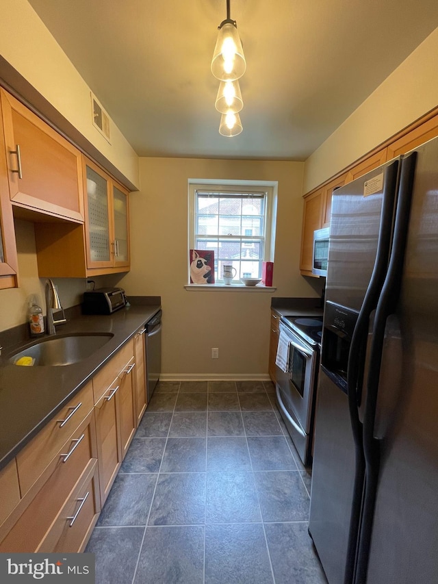 3750 39th St NW Unit C147, Washington, DC 20016 - kitchen with stainless steel appliances, a sink, dark countertops, glass insert cabinets, and baseboards